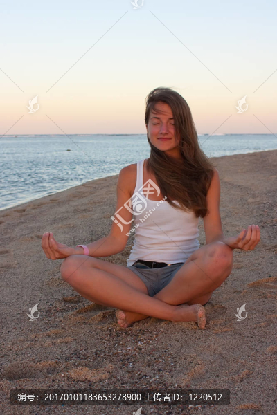 在海灘上練習(xí)瑜伽的年輕女子
