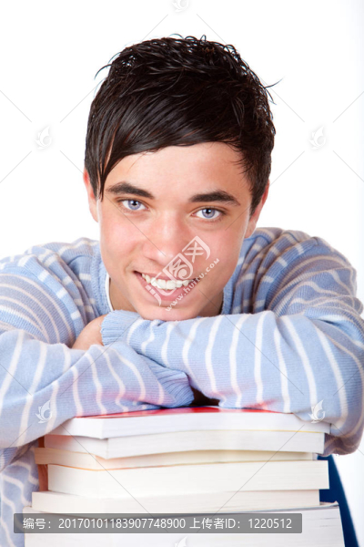 年輕快樂的英俊男學(xué)生靠學(xué)習(xí)書