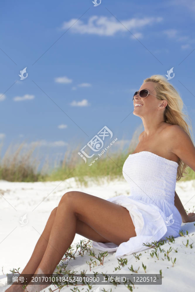 美麗的金發(fā)女子在Beach的白色連衣裙和太陽鏡