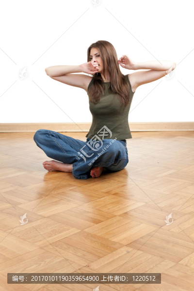 打哈欠的女人坐在地板上，雙腿交叉