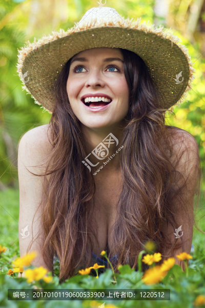 美麗的年輕女子躺在草地上笑