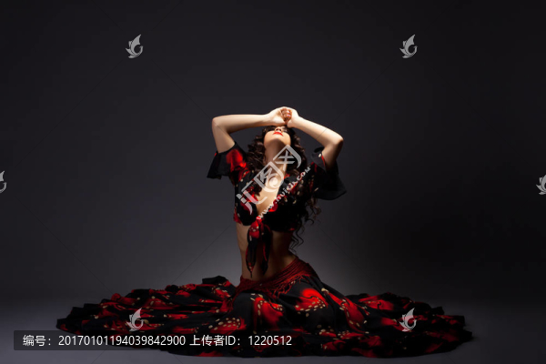 年輕女子坐在吉普賽黑色和紅色服裝