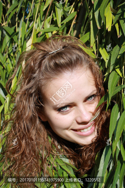 棕色头发的女人在绿叶后面