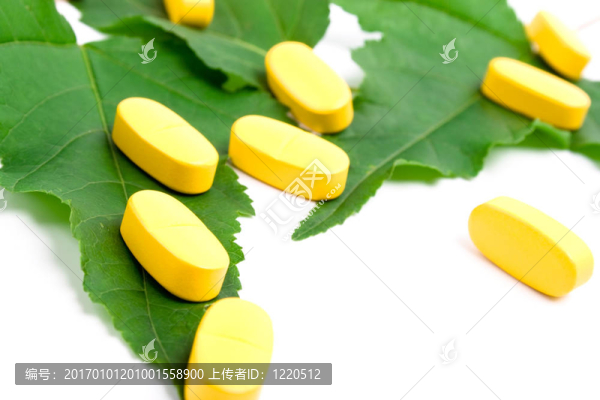 綠色葉子上的黃色維他命藥丸