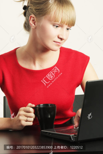 金發(fā)女商人在紅工作的筆記本電腦