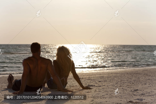 在森塞特海灘上坐著的年輕男女情侶