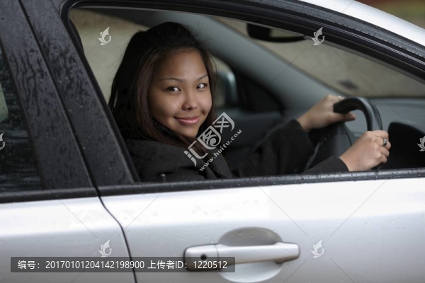 年輕女子開著她的新車。