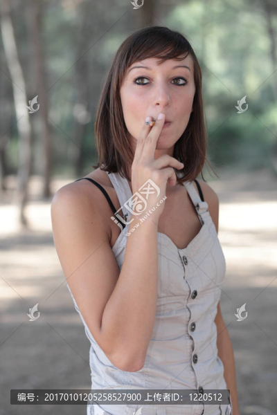 一個漂亮的年輕女人在戶外點燃香煙的肖像