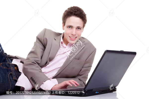 年輕人面帶微笑，用筆記本電腦打字；在白色上孤立