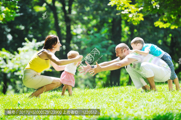 快樂的年輕夫婦和他們的孩子在公園玩得開心