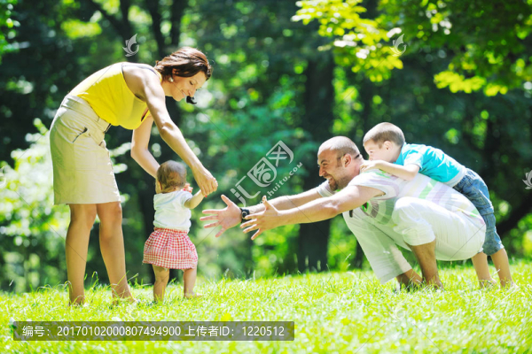 快樂的年輕夫婦和他們的孩子在公園玩得開心