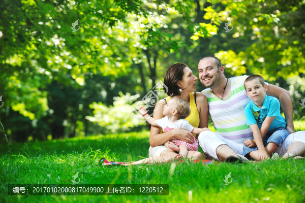 快樂的年輕夫婦和他們的孩子在公園玩得開心