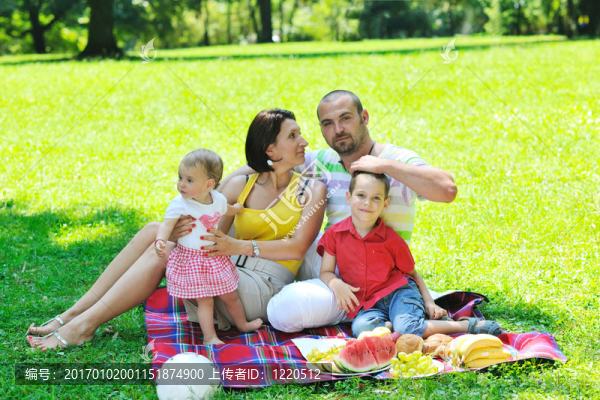 快樂的年輕夫婦和他們的孩子在公園玩得開心