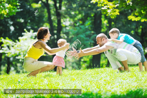 快樂的年輕夫婦和他們的孩子在公園玩得開心