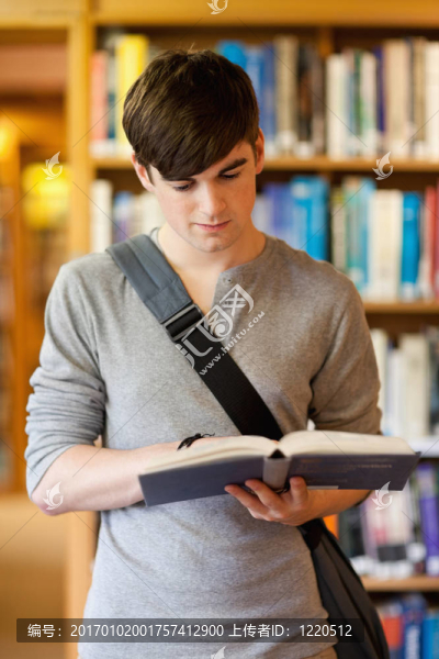 一個英俊的學(xué)生在讀一本書