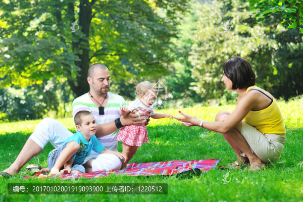 快樂的年輕夫婦和他們的孩子在公園玩得開心