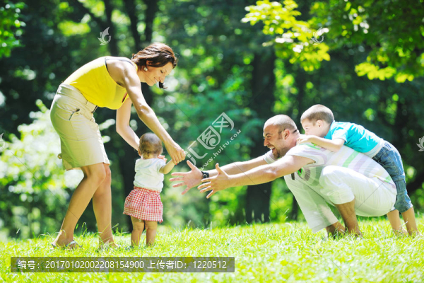 快樂的年輕夫婦和他們的孩子在公園玩得開心