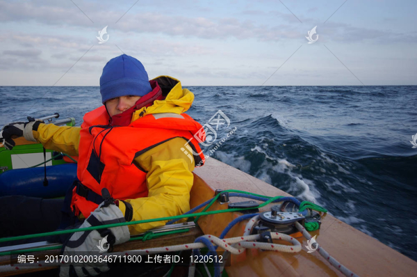 年輕白人女子坐在一個(gè)小帆船在海上的海上（選擇性重點(diǎn)；專注于女人）
