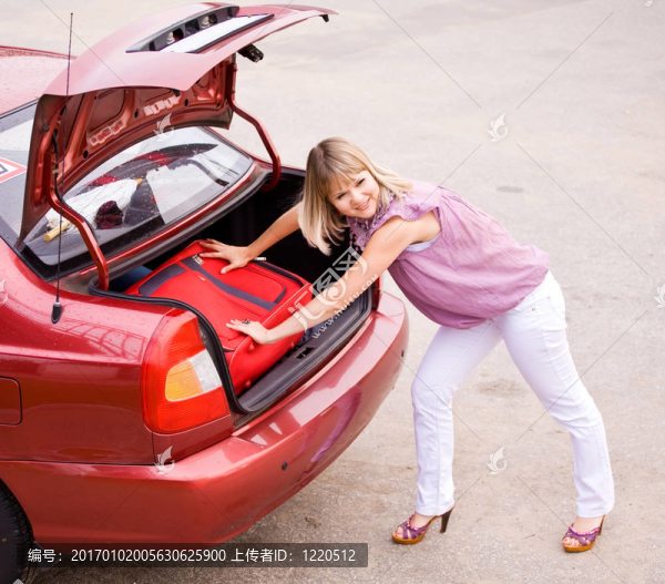 在車?yán)飵еt色行李箱的年輕女子