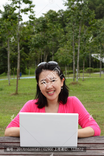 在公園里用筆記本電腦的女人