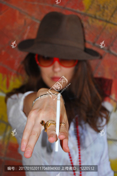 年輕的女孩站在明亮的院子和黃色的墻附近
