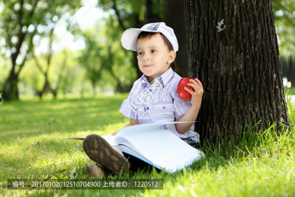 一個男孩在公園里拿著一本書的肖像