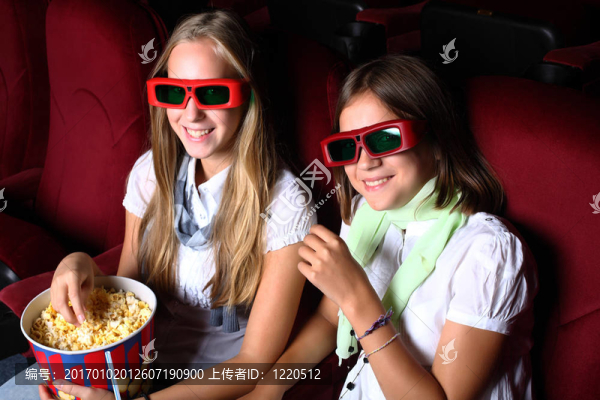 兩個年輕女孩在電影院看電影