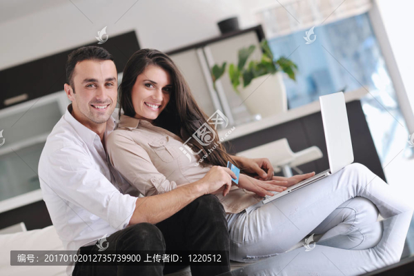 快樂夫婦放松和工作在筆記本電腦在現(xiàn)代家庭