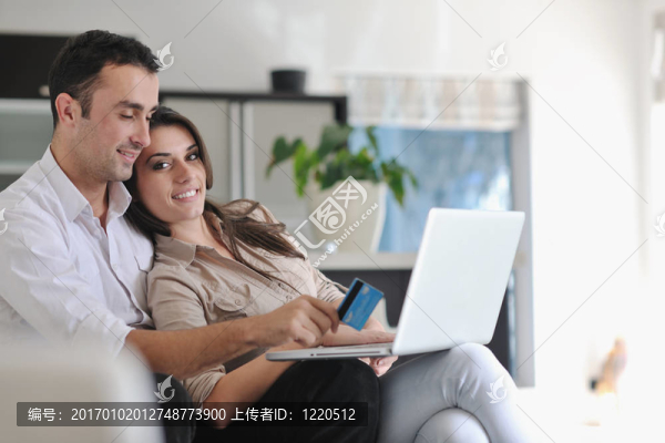 快樂夫婦放松和工作在筆記本電腦在現(xiàn)代家庭