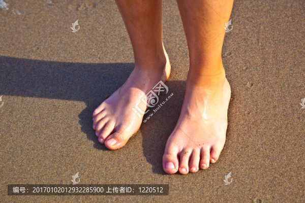 沙灘上濕漉漉的沙灘上男孩的腳