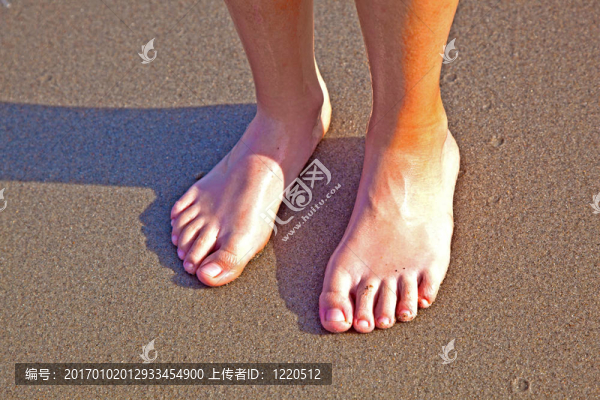 沙灘上濕漉漉的沙灘上男孩的腳