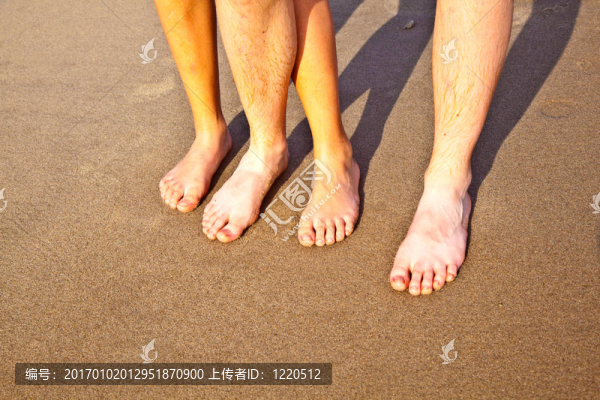 在潮濕的沙灘上，父親和兒子的雙腳