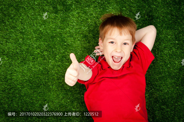 躺在綠色草坪上的男孩