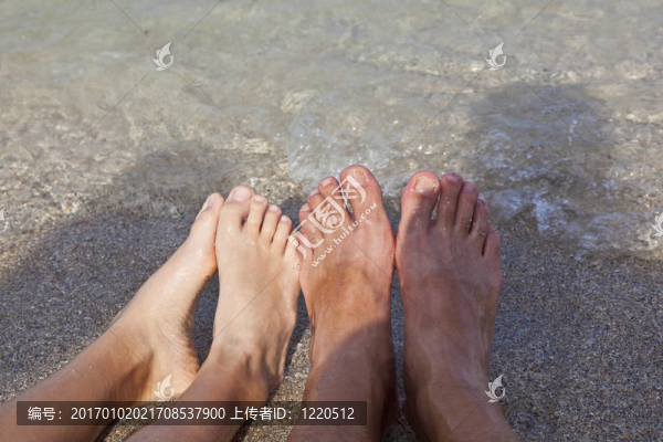 海灘上父子倆的腳