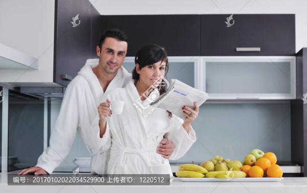 早餐時(shí)在廚房看報(bào)紙的快樂(lè)情侶