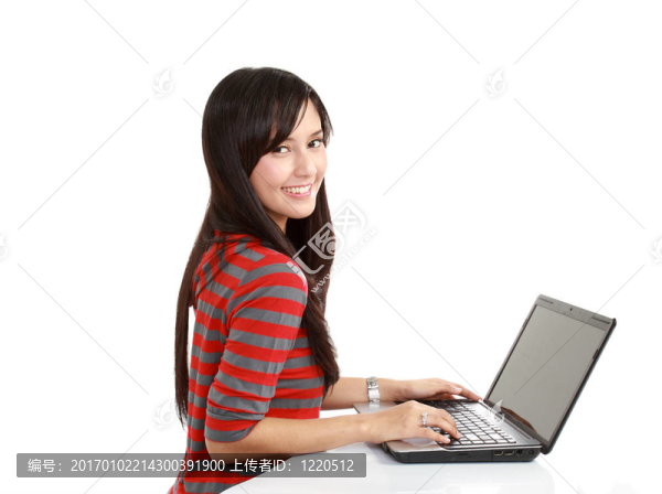 微笑的年輕女子坐在筆記本電腦上的肖像。與孤立的背景