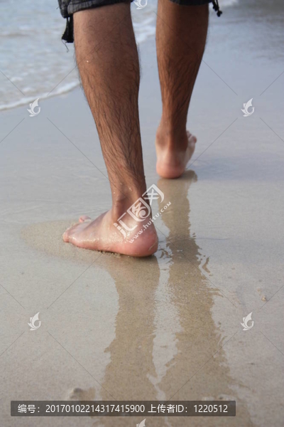 在海灘上行走的人的腿