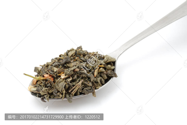 在白色背景上分離的金屬匙中的干綠茶