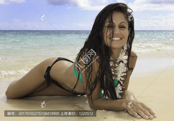 美麗的女孩躺在沙灘上