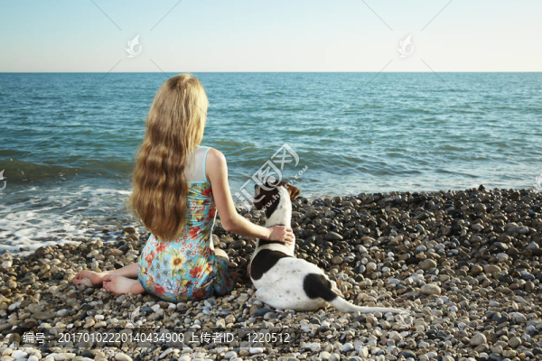 美麗的女人與狗在海灘上