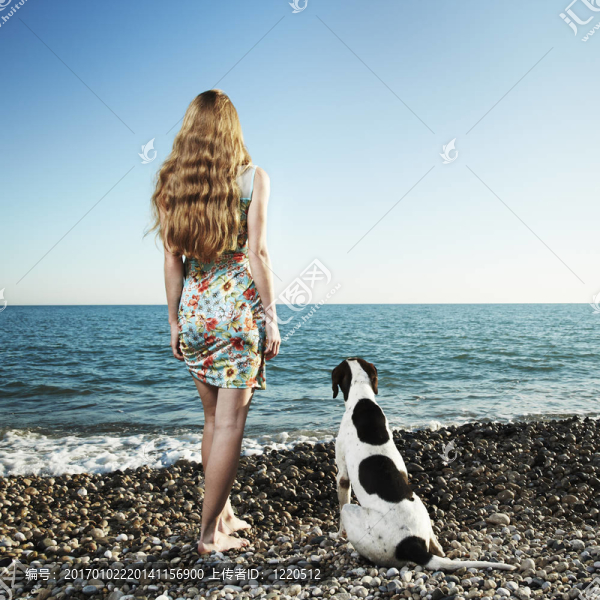 美麗的女人與狗在海灘上
