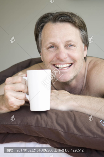 男人在床上喝咖啡。