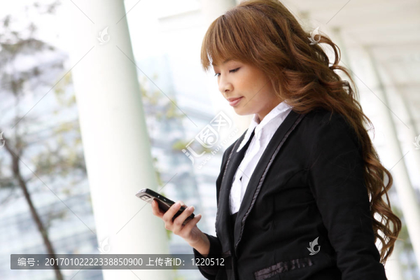 美麗的商業(yè)婦女在電話在現(xiàn)代建筑