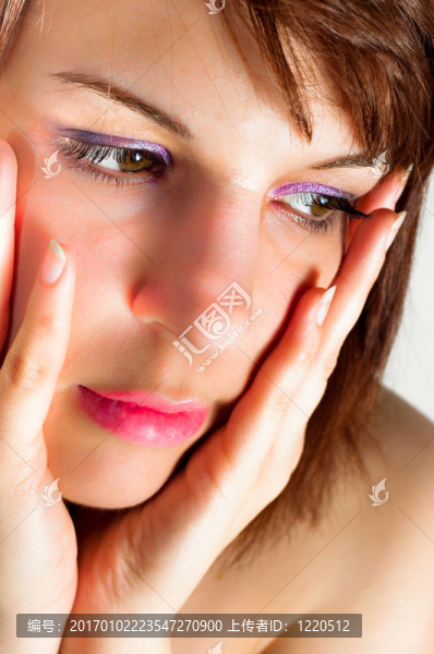 一個年輕的女人抱著她的臉和手的特寫