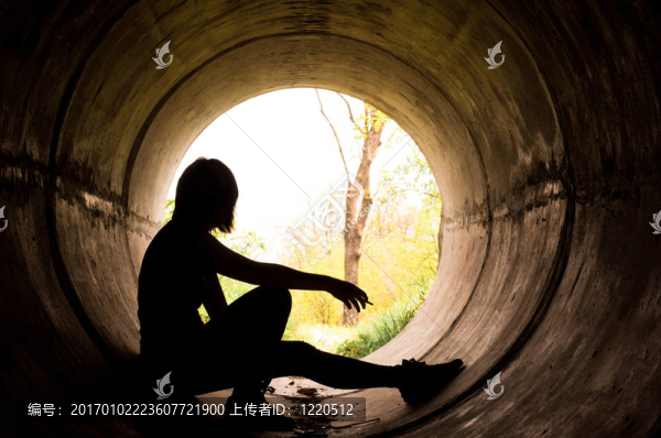 一個年輕女孩在下水道里吸煙的剪影