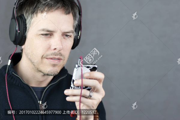 戴著耳機的人看著MP3播放器