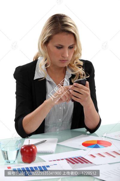 一個商人發(fā)短信她桌上的圖表。