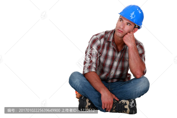 一個憂郁的建筑工人坐在地板上。