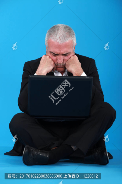 困惑的中年商人與筆記本電腦