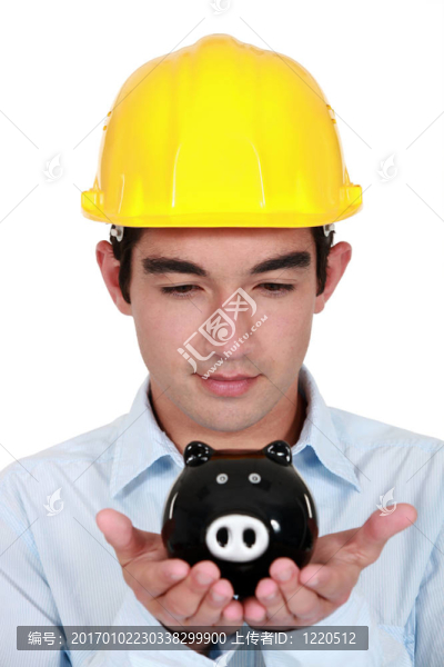 年輕的建筑工人手里拿著存錢罐